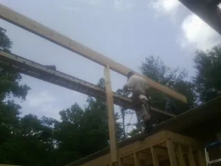 Carpenter setting a ridge beam over a new addition frame — Ice Dam Removal by Roofing Brothers in Grand Meadow