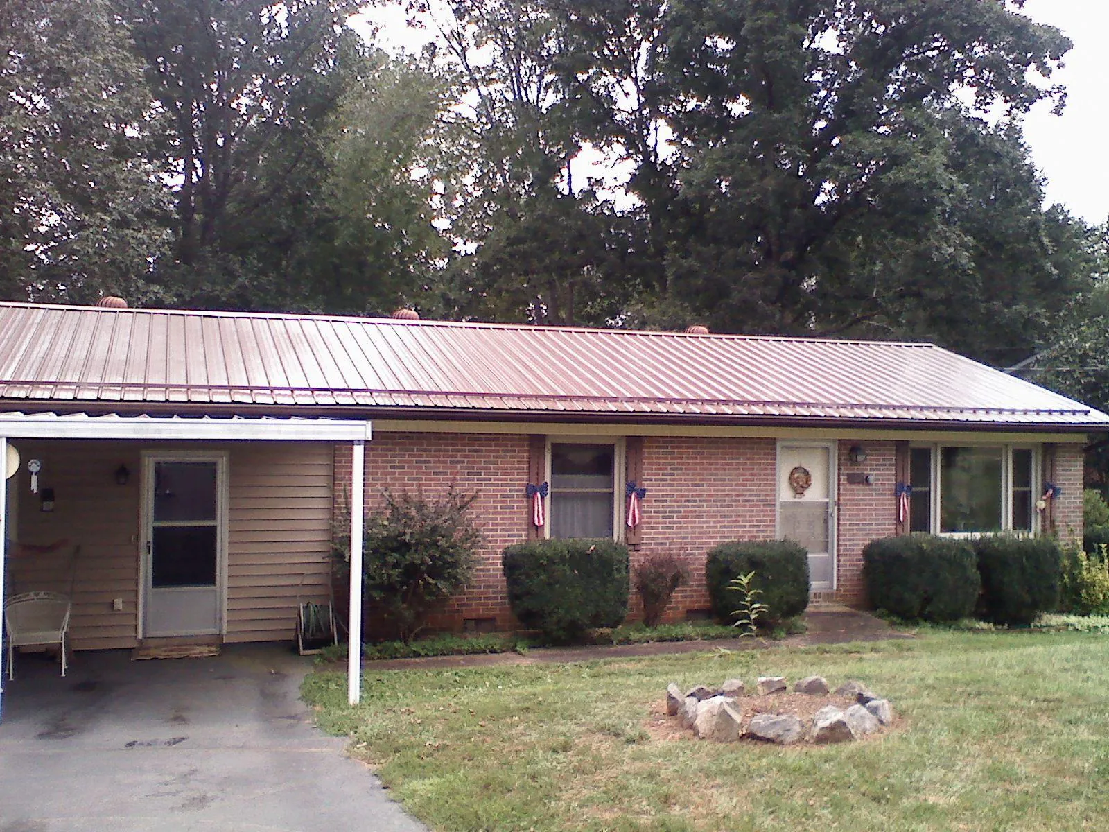 Bronze metal roof and carport on a brick ranch home — Roof Repair work by our crew in Grand Meadow